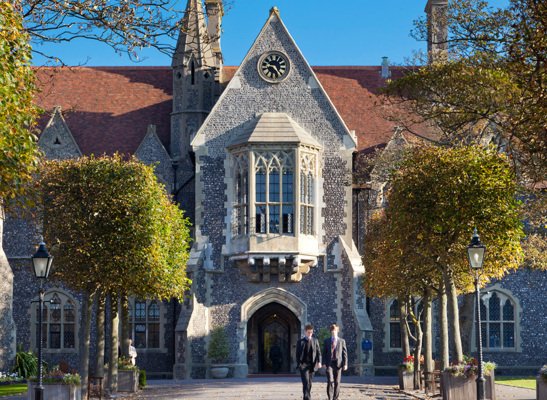 Main Building with pupils walking through the Quad in the sunshine