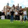 Pupils in the Quad jumping for joy on A-Level Results Day holding their results thumbnail