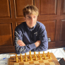 Henry sitting in front of a chess board at the Cambridge International Chess Congress thumbnail