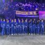 Pupils in blue boiler suits on the stage at a Robotics competition thumbnail