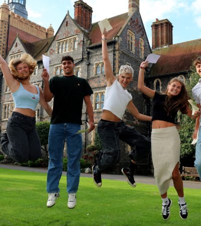 Pupils in the Quad jumping for joy on A-Level Results Day holding their results