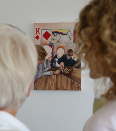 Parents gazing at a painting displayed in the end of year Art exhibition