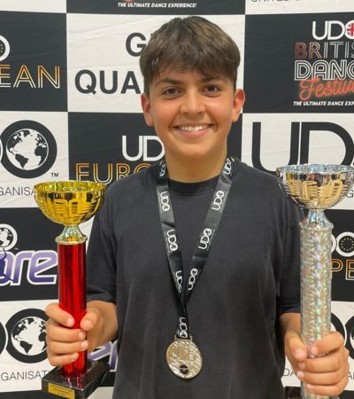 Forrest holding his trophies and with a medal at the UDO Southern Streetdance Championships