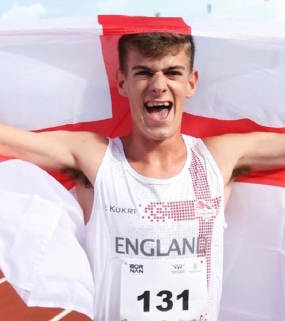 Miles Waterworth holding the English flag around him at the Youth Commonwealth Games