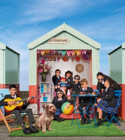 Prep School pupils playing together in a beach hut on Brighton seafront on a sunny day