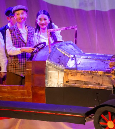 Prep School pupils on stage in the car performing in their production of Chitty Chitty Bang Bang