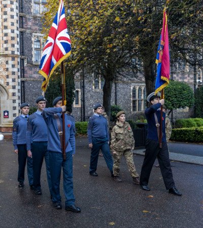 Pupils in CCF holding flags on parade for Remembrance Day