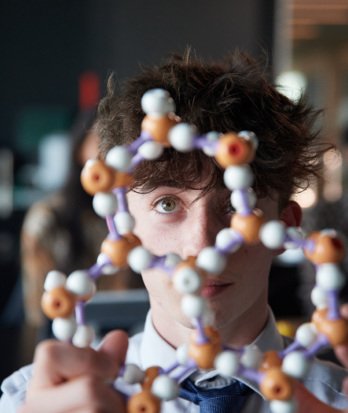 A-Level pupil examining a model of a molecular structure in a Chemistry lesson