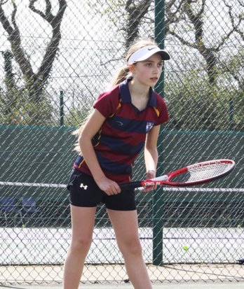 Prep School pupil getting ready to return a serve in a tennis match