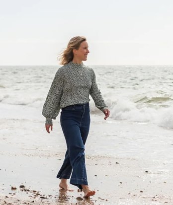 Becca from Cloud Seven meditation walking barefoot along a sandy beach