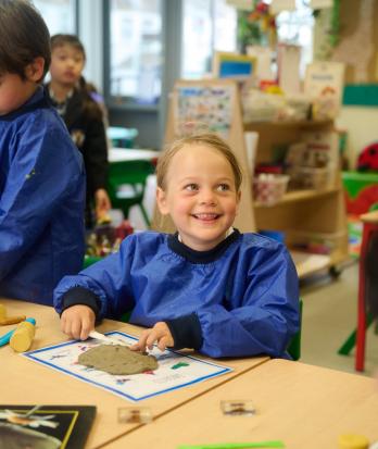 Pre-Prep pupils in aprons using tools to make models out of clay