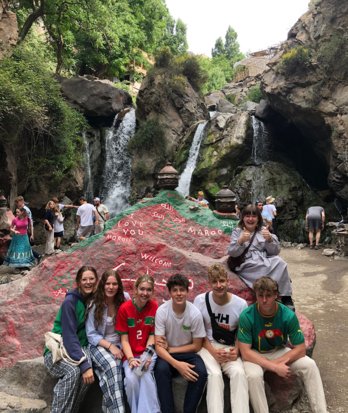 Pupils sitting on a rock by waterfalls in Morocco on a French Trip