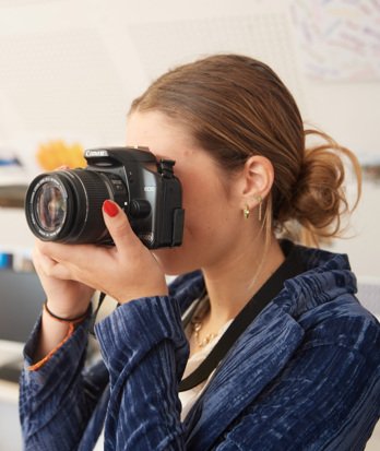 Pupil with a Canon camera taking a picture in an A-Level Photography lesson