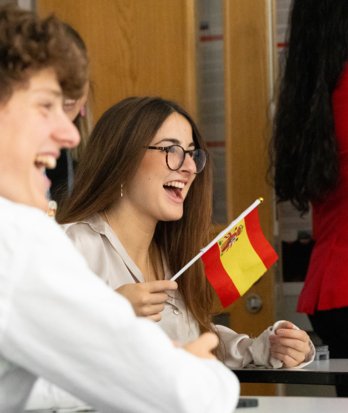 Pupil holding a Spanish flag and enjoying their Spanish lesson