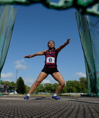 Pupil holding a discus in the cage at the back of the circle and preparing to throw at an Athletics meet