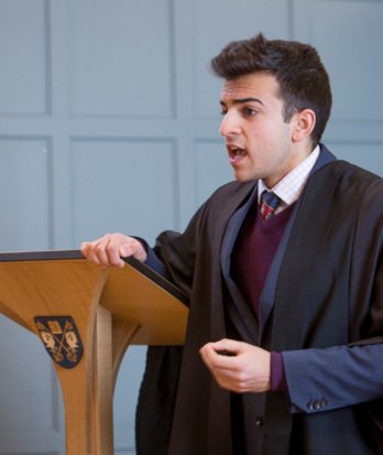 Pupil standing behind a lectern giving an opening argument at Debating Club