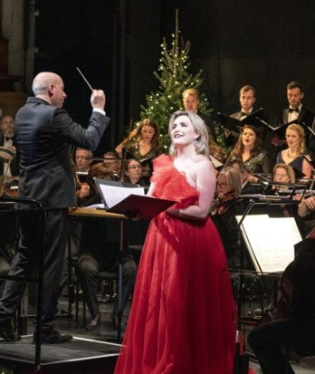 Singer performing a Christmas concert at Glyndebourne accompanied by an orchestra and choir