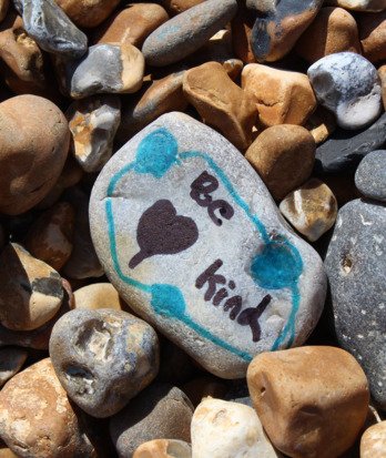 Rock with 'Be Kind' written on it and a heart drawing done at Beach School on Brighton beach