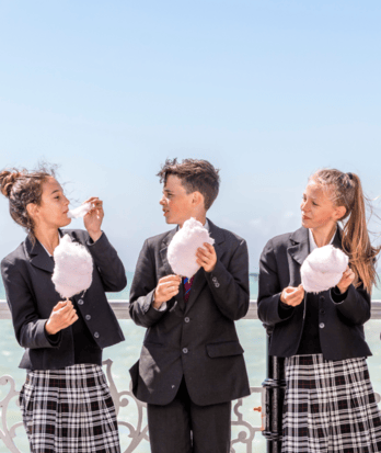 Pupils enjoying eating candy floss on Brighton Pier