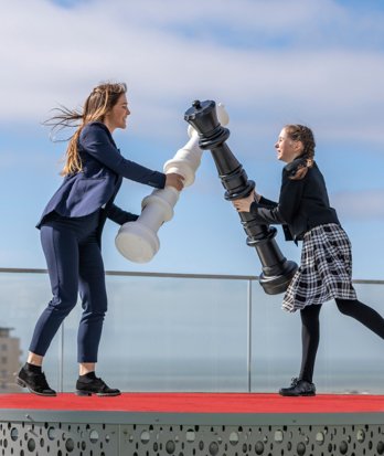 Pupils pretending to duel with giant chess pieces in the Sky Garden on SSS Roof