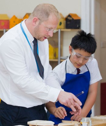 Teacher assisting a pupil with their project in a DT lesson