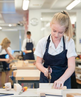 4th Form pupil sawing a block of wood in a DT lesson