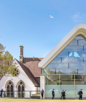 Pupils walking past the Sarah Abraham Recital Hall on a sunny day