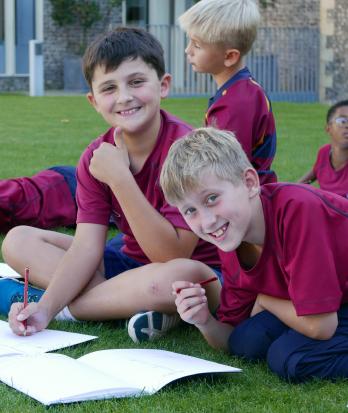 Prep School pupils in their games kit enjoying sitting in the Quad sketching their view