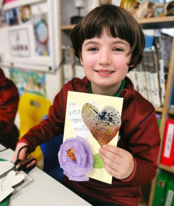 Pre-Prep pupil enjoying making a card with hearts and flowers in Art Club