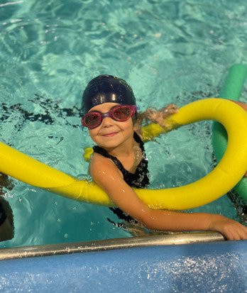 Pre-Prep pupil with a pool noodle enjoying swimming