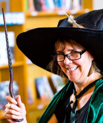 Librarian Debbie McCullough dressed as Minerva McGonagall in the library for Harry Potter club