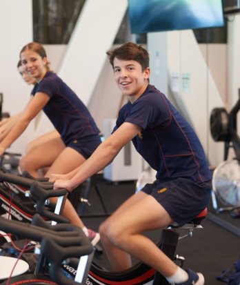 Boarders in the gym enjoying being on the spin bikes for evening activities