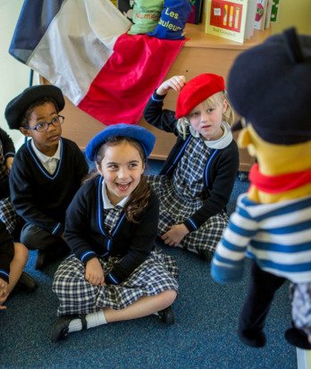 Pre-Prep pupils wearing berets laughing at a French puppet in their lesson