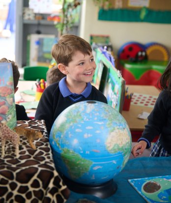 Pre-Prep pupil with a globe enjoying learning Geography