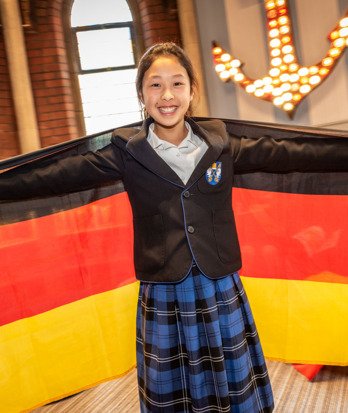 Prep School pupil learning German happily holding the German flag