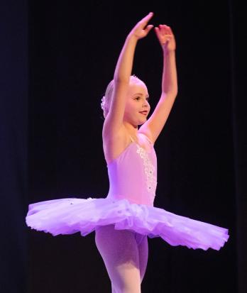 Prep School pupil in a tutu performing a ballet dance on stage at the Dance Show