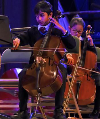 Prep School pupils playing as part of a strings group in a concert in the Hall