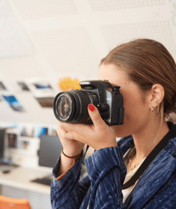 Pupil with a Canon camera taking a picture in an A-Level Photography lesson