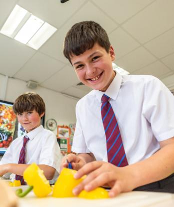 Prep School pupils in Cookery Club chopping up yellow peppers