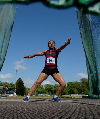 Pupil holding a discus in the cage at the back of the circle and preparing to throw at an Athletics meet