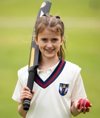 Prep School pupil holding a cricket bat and ball