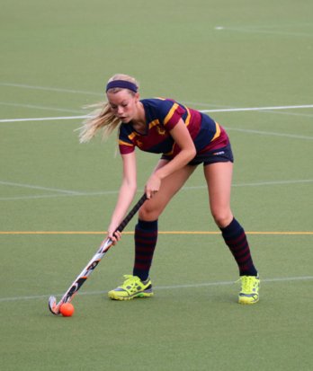 1st XI Hockey player with the ball on their stick preparing to push the ball towards the goal