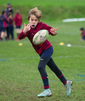 Prep School pupil throwing a rugby ball in a Games session