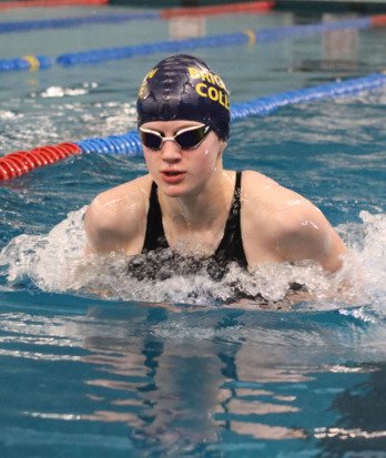 Astrid competing in a Brighton College Swimming hat competing in a gala in the Lido swimming pool