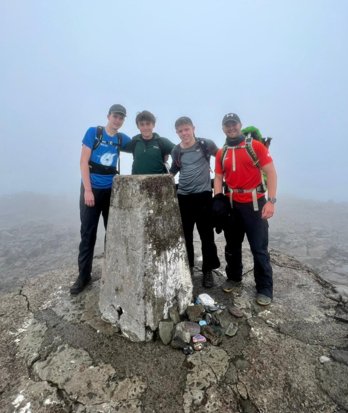 Pupils at the top of a mountain as part of the 3 Peaks Challenge to raise money for charity