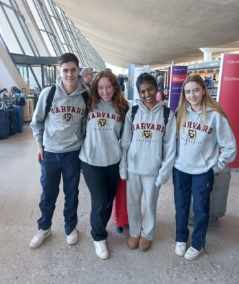 Pupils at the airport wearing Harvard University jumpers on a tour of US Universities