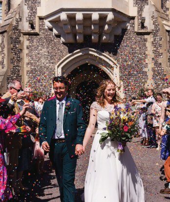 Happy Newlyweds enjoying the confetti toss as they walk through the Quad