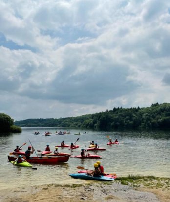 Year 7 pupils enjoying kayaking on a lake on a trip