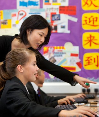 Mandarin teacher showing a Lower School pupil something on a computer in a Mandarin lesson