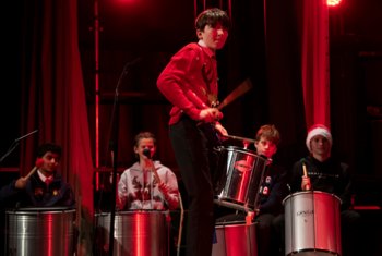  Pupils in Christmas jumpers performing a group drum piece in the Christmas Concert 